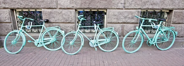 Tre grønne sykler mot en vegg i Amsterdam Nederland – stockfoto