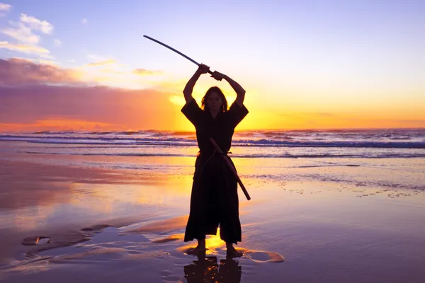 Young samurai women with Japanese sword(Katana) at sunset on the — Stock Photo, Image