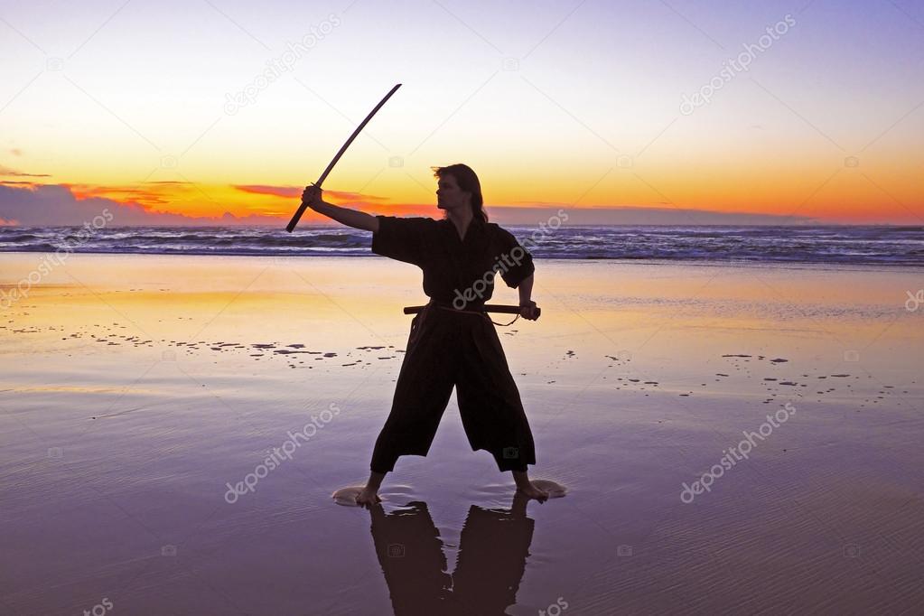 Young samurai women with Japanese sword(Katana) at sunset on the