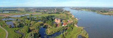 Loevestein şatosundan hava manzarası ve Hollanda 'daki Merwede nehri gün batımında.