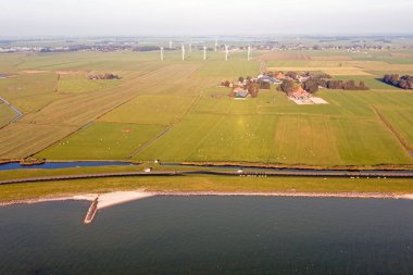 Hollanda 'da tipik bir Hollanda manzarasından havadan: düz arazi, koyun, yel değirmeni ve su
