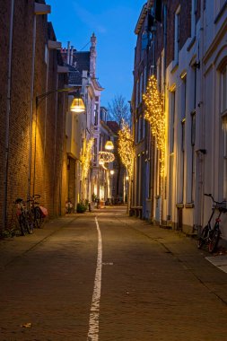 Hollanda 'nın Deventer kentindeki eski cadde Noel zamanı günbatımında.