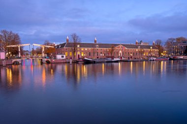 Amsterdam 'dan şehir manzarası Hollanda' daki Amstel nehrinde gün batımında.