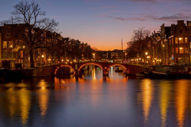 Amsterdam 'dan şehir manzarası Hollanda' daki Amstel nehrinde gün batımında.
