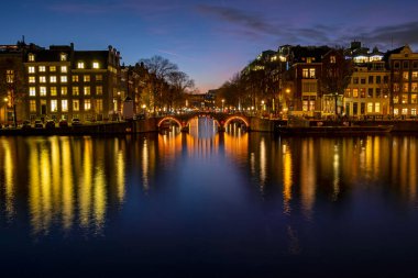 Amsterdam 'dan şehir manzarası Hollanda' daki Amstel nehrinde gün batımında.