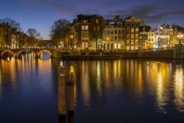 Amsterdam 'dan şehir manzarası Hollanda' daki Amstel nehrinde gün batımında.