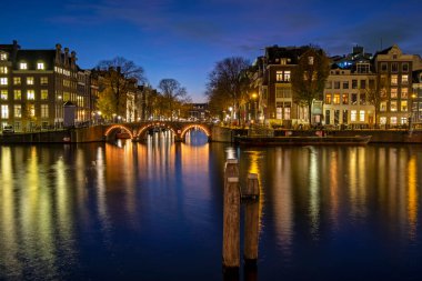 Amsterdam 'dan şehir manzarası Hollanda' daki Amstel nehrinde gün batımında.