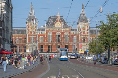AMSTERDAM, NETHERLANDS - September 22, 2021: City scenic from Amsterdam on the Damrak with the Central Station in the Netherlands