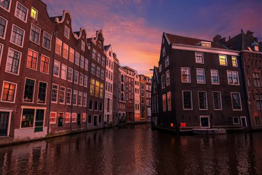 Hollanda 'nın Amsterdam kentindeki şehir merkezindeki geleneksel evler gün batımında
