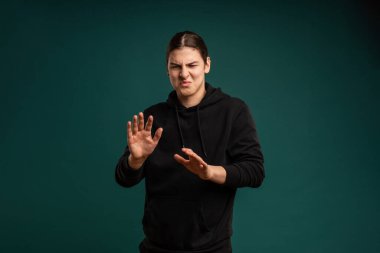 Genç bir adamın iğrenç ifadesi. Erkek ruh halinin kırpılmış stüdyo portresi