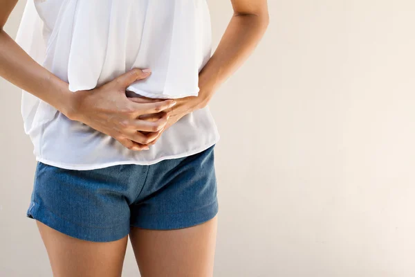 Menstruationssmärta eller magont, hand hålla magen närbild — Stockfoto