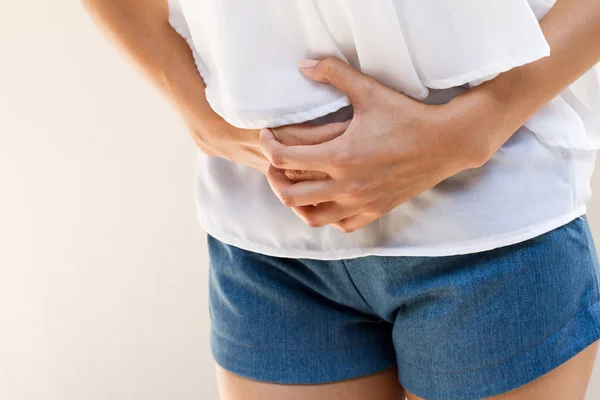 Dolor de menstruación o dolor de estómago, mano sosteniendo el vientre de cerca — Foto de Stock