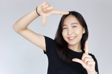 Mutlu, gülümseyen, kendine güveni tam bir Asyalı genç kadın.