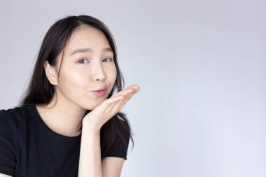 Mutlu bir kadın öpüşüyor ya da hava öpücüğü veriyor.