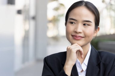 Happy and successful asian female office worker thinking
