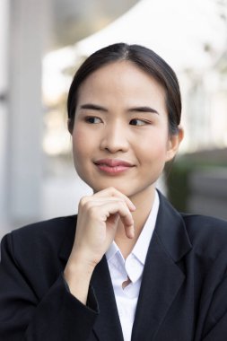 Happy and successful asian female office worker thinking