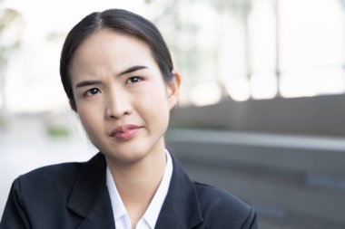 Upset asian woman office worker looking up