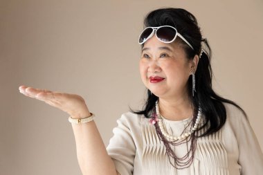 happy smiling fashionalble old senior woman pointing