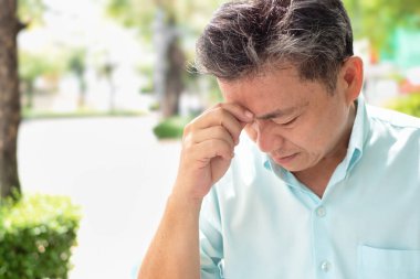 Stres baş ağrısı, baş dönmesi ya da baş dönmesi çeken yaşlı bir adam.