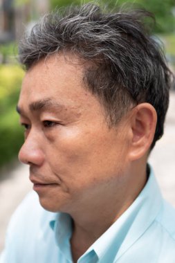 Yaşlı yaşlı adamın gri saçları var.