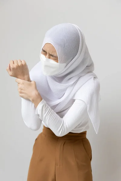 年轻的穆斯林妇女患者 戴口罩 手握腕部或手部疼痛 疾病概念Cts 腕部疼痛 触发手指 骨关节炎 痛风症状 德克万氏病 — 图库照片