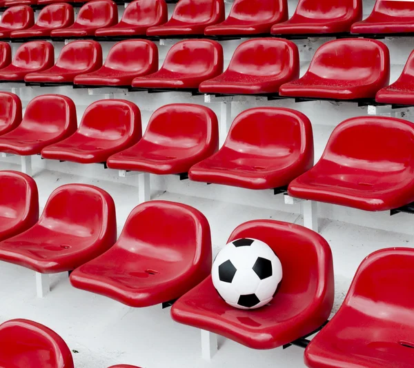 Ряды мест на красном футбольном стадионе с номерами — стоковое фото