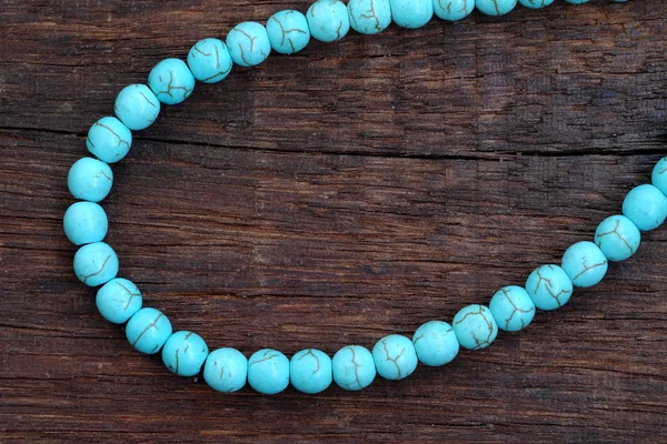 Turquoise bead on a wooden — Stock Photo, Image