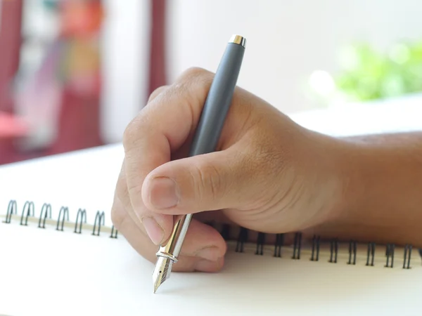 Close up of human hand with pen