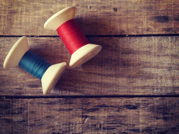 Thread rolls on wood background old retro vintage style — Stock Photo, Image
