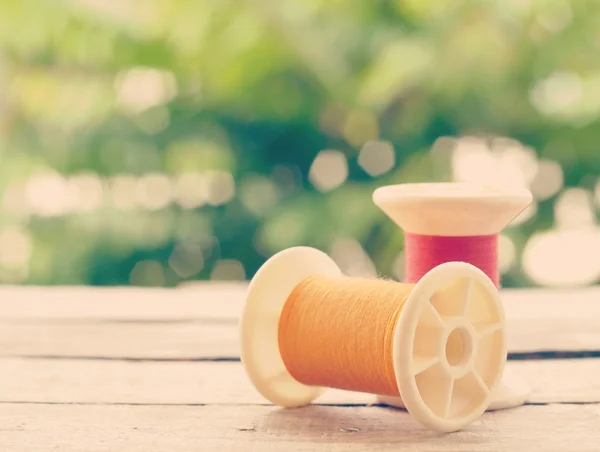 Rollos de hilo sobre fondo de madera viejo estilo vintage retro —  Fotos de Stock