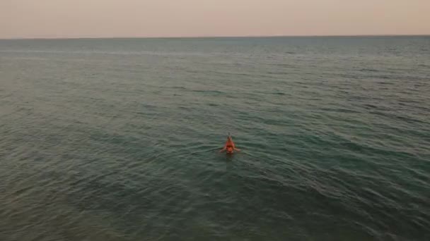 Images 4k au-dessus du coucher du soleil de mer clair. Jeune femme viennent dans l'eau mer océan maillot de bain bikini plongée masque de plongée. — Video