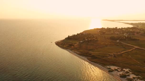 4k antenn ovanifrån ovanför solnedgången sand strand hav. Grekland kust by små hus bukt thrakiska havet — Stockvideo