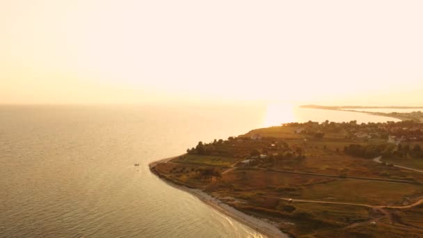 4k vista aerea dall'alto sopra il tramonto spiaggia di sabbia mare. Grecia villaggio balneare piccole case baia Tracia mare — Video Stock