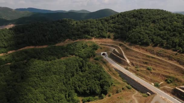 Автомобиль въезжает в туннель воздушный беспилотник вид сверху над Грецией дневное лето 4K видео — стоковое видео