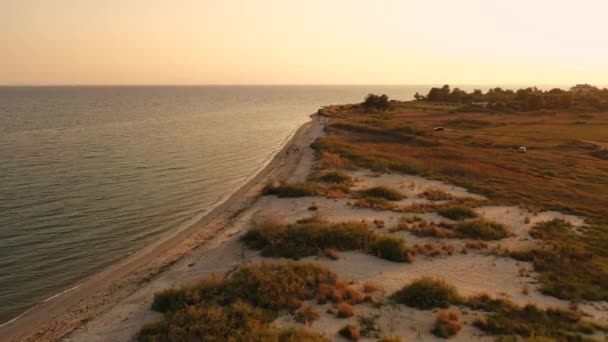 4k vista aerea dall'alto sopra il tramonto spiaggia di sabbia mare. Grecia villaggio balneare piccole case baia Tracia mare — Video Stock