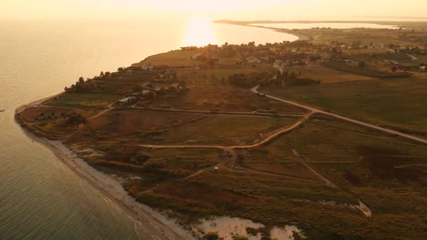 4k vista aerea dall'alto sopra il tramonto spiaggia di sabbia mare. Grecia villaggio balneare piccole case baia Tracia mare — Video Stock