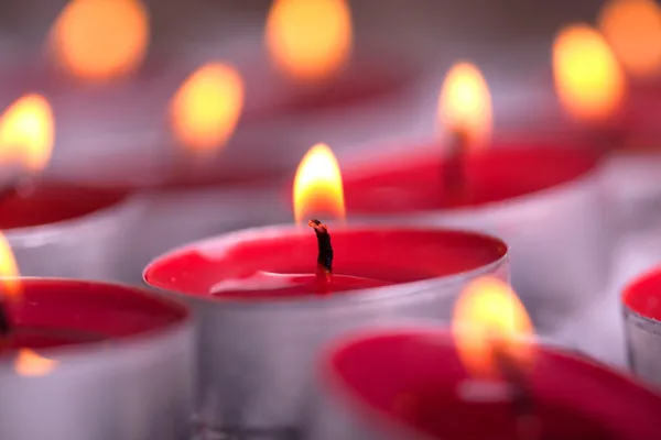 Tealights rojo iluminado con llama dorada — Foto de Stock