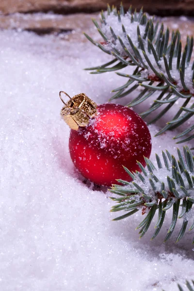 Rote Weihnachtskugel auf Schnee liegend — Stockfoto