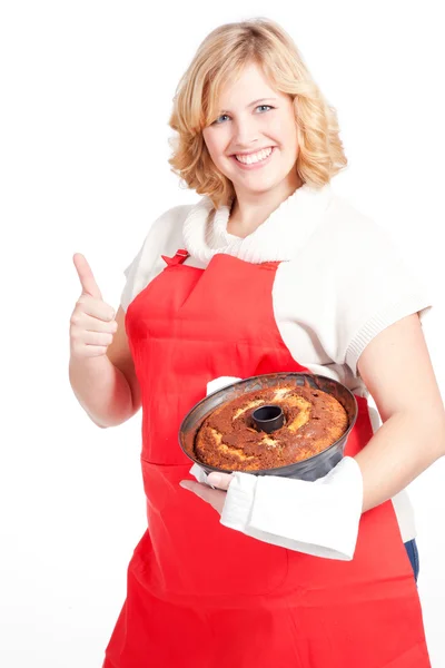 Blond kvinna med bundt cake och rött förkläde — Stockfoto
