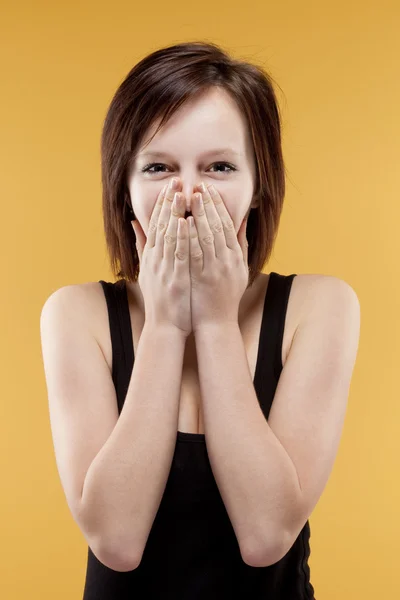 Adolescente sorprendida cubriendo la boca con sus manos — Foto de Stock