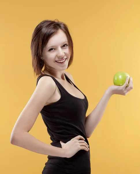 Teenage girl holding a green apple smiling — Stock Photo, Image