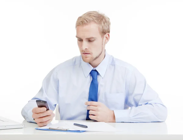 Jeune homme au bureau avec téléphone portable — Photo