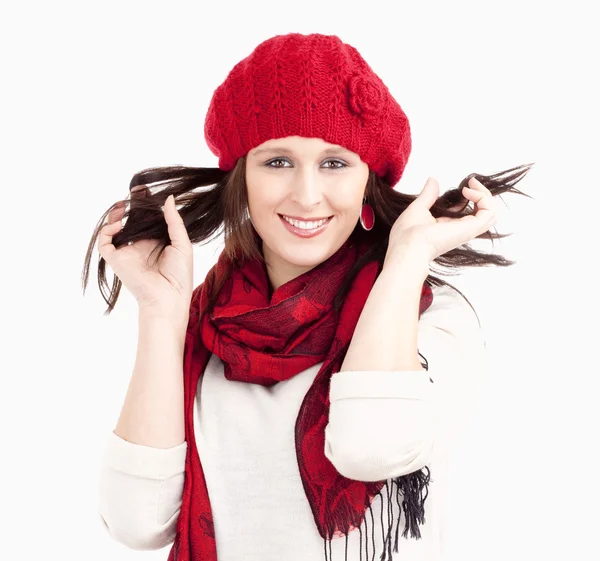Ung kvinde i rødt cap og tørklæde smilende - Stock-foto