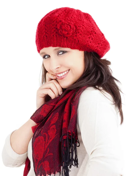 Молодая женщина в красной шапке и шарф улыбаясь — стоковое фото