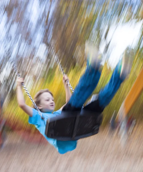 Fiú a swing a játszótéren — Stock Fotó