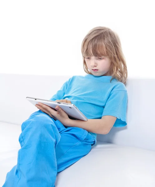 Niño con el pelo largo y rubio jugando con la tableta digital — Foto de Stock