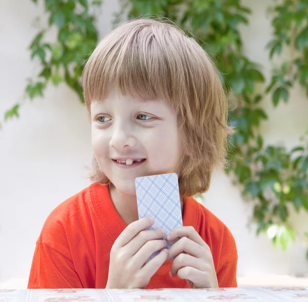 Niño con el pelo rubio jugando a las cartas — Foto de Stock