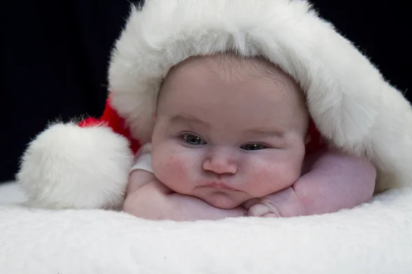 Lugt Baby in Weihnachtsmannmütze — Stockfoto