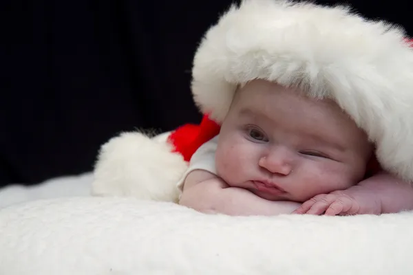 Baby guckt in Weihnachtsmütze — Stockfoto