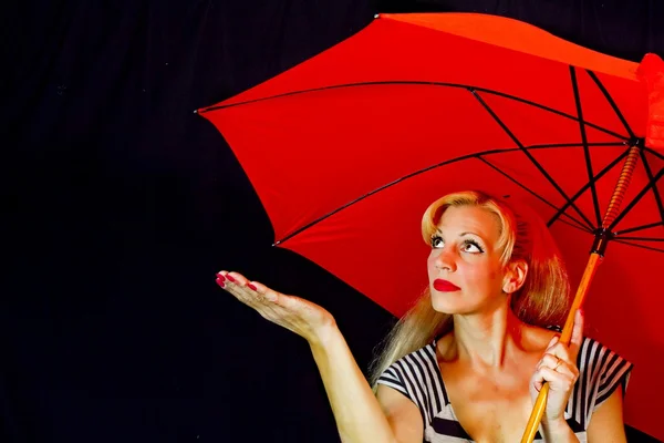 Kobieta ubrana pogrubienie czerni i bieli z czerwony parasol — Zdjęcie stockowe